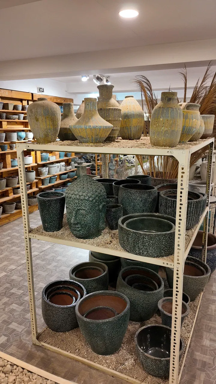 Dark green glazed pots, a Buddha head and tall vases