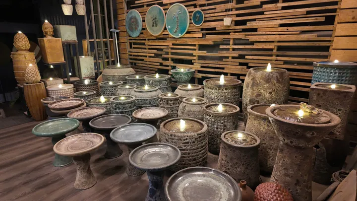 Rows of turquoise and grey glazed birdbaths and fountain bowls