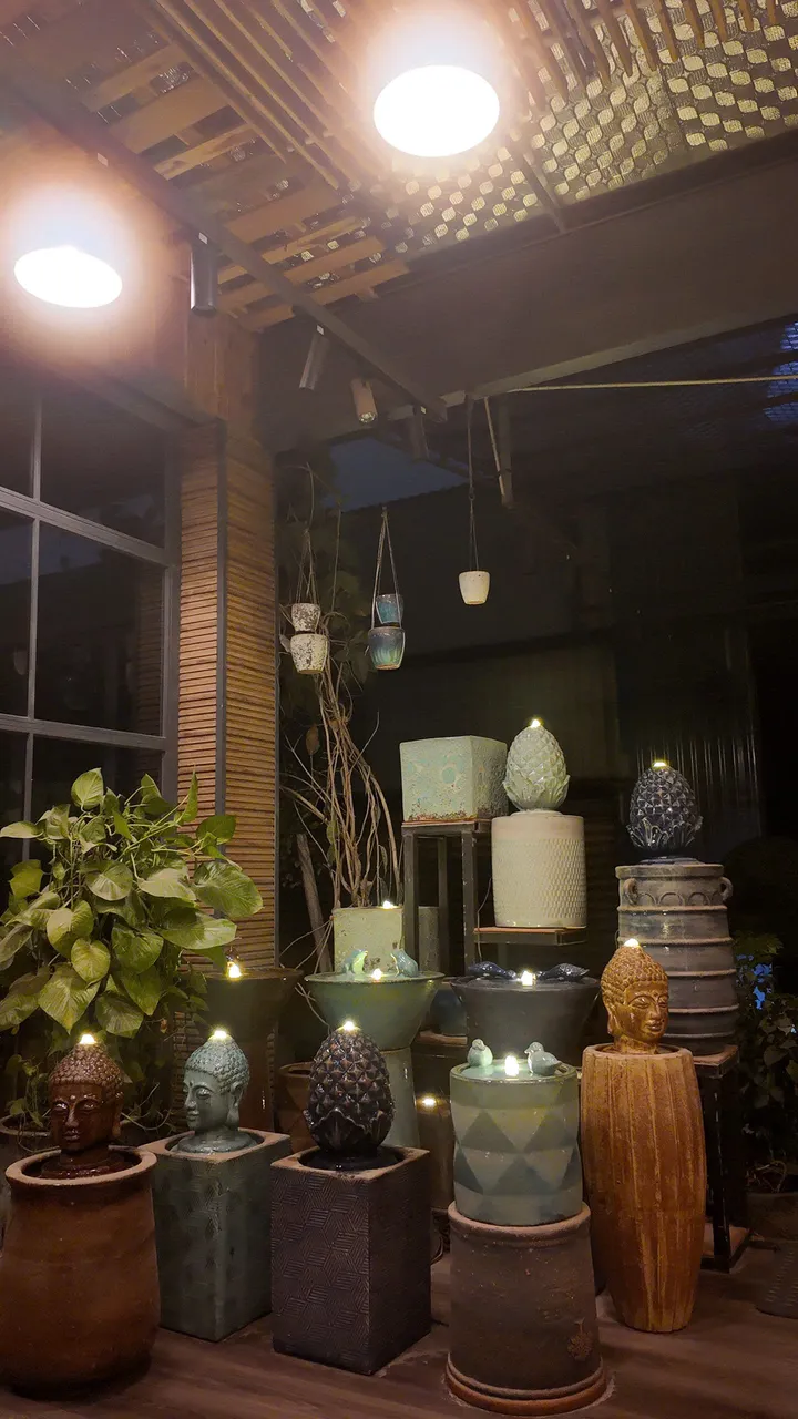 Fontaines en céramique tête de Bouddha et pomme de pin, éclairées le soir