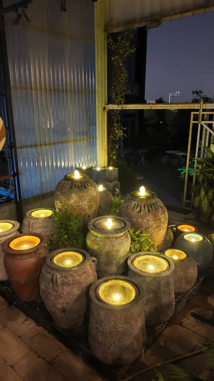 Clay jar fountains lit from inside at night