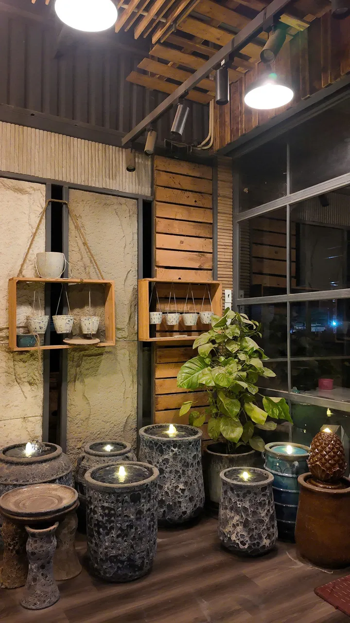 Mosaic-glazed ceramic fountains glowing in a dark showroom
