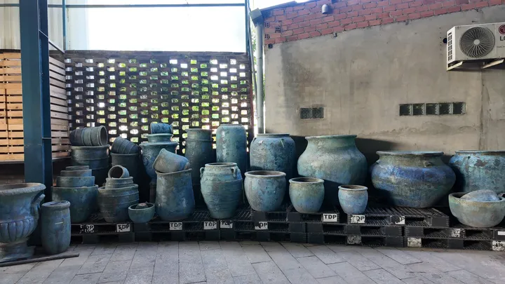 Jarres et pots émaillés bleu océan alignés dans la cour