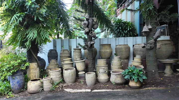 Sand-finish weathered garden pots and jars under tropical trees